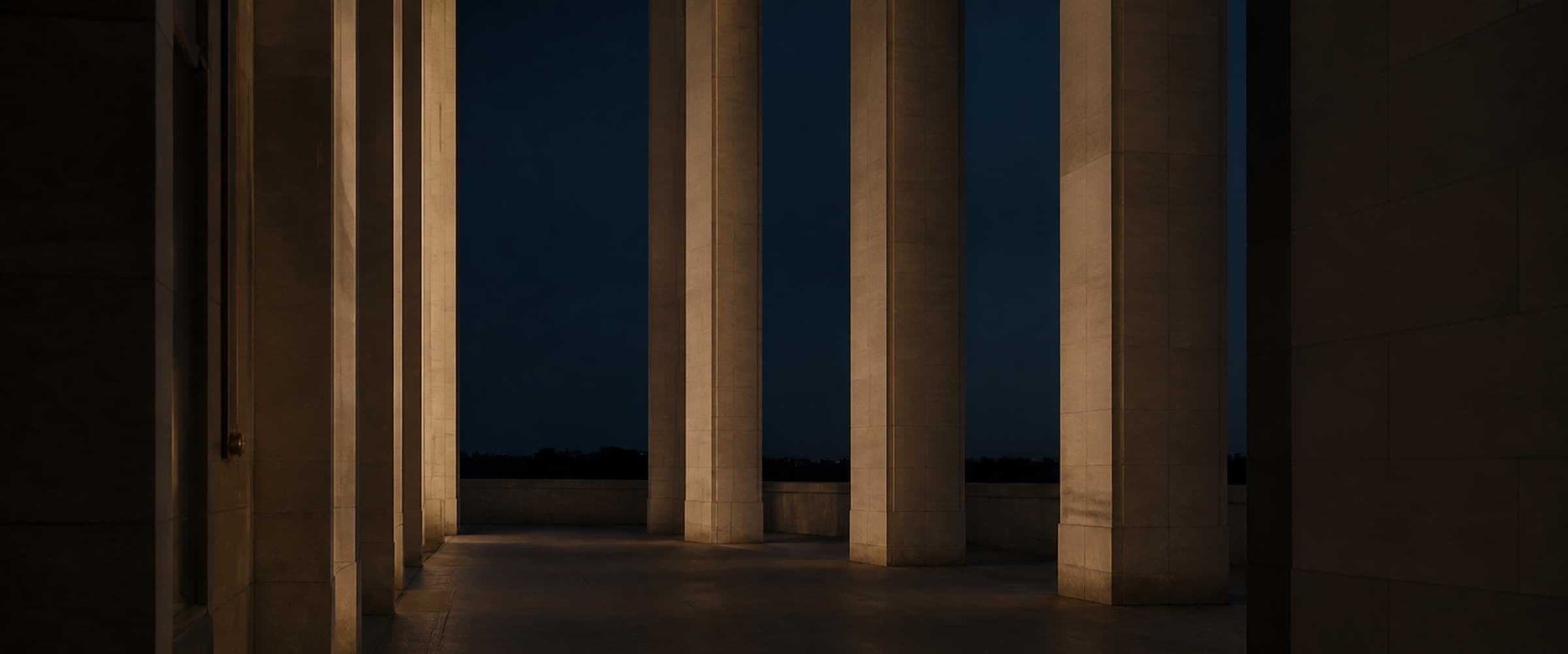 A quiet limestone colonnade in Manhattan at dusk